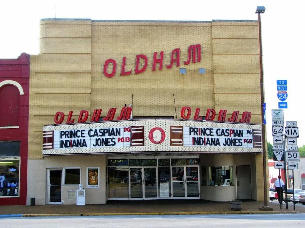 An inviting view of a classic theater marquee with movie titles, decorative lighting, and well-preserved architectural details. The historic theater exterior hints at entertainment options available nearby, evoking nostalgia and the thrill of a night out with friends.